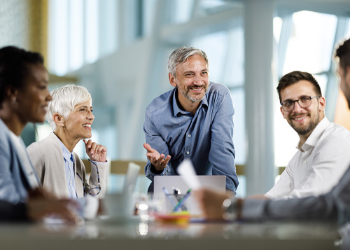 confident female leader in white shirt talking to her team